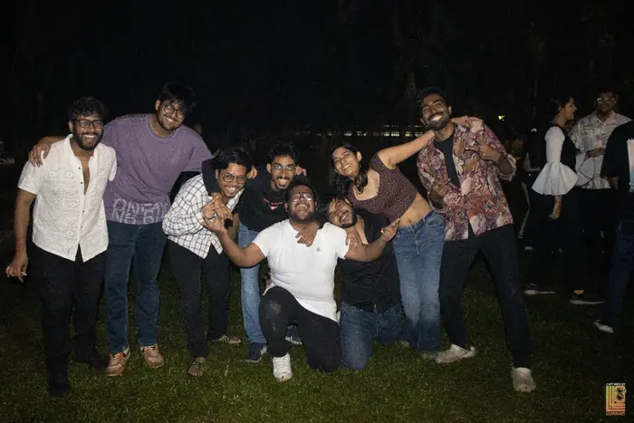 Group of students posing together on the lawn at night