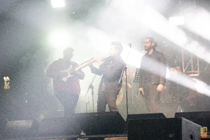 Band performing through stage haze and light beams